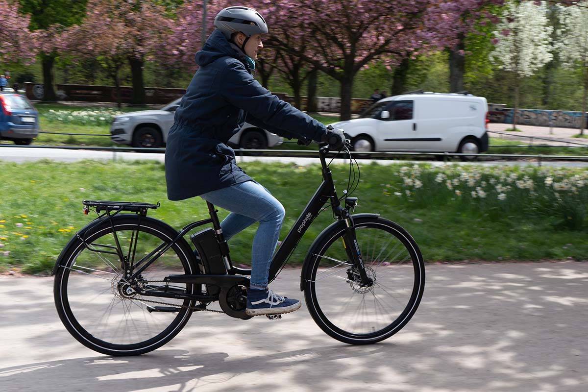Frau fährt mit einem E-Bike durch den Park