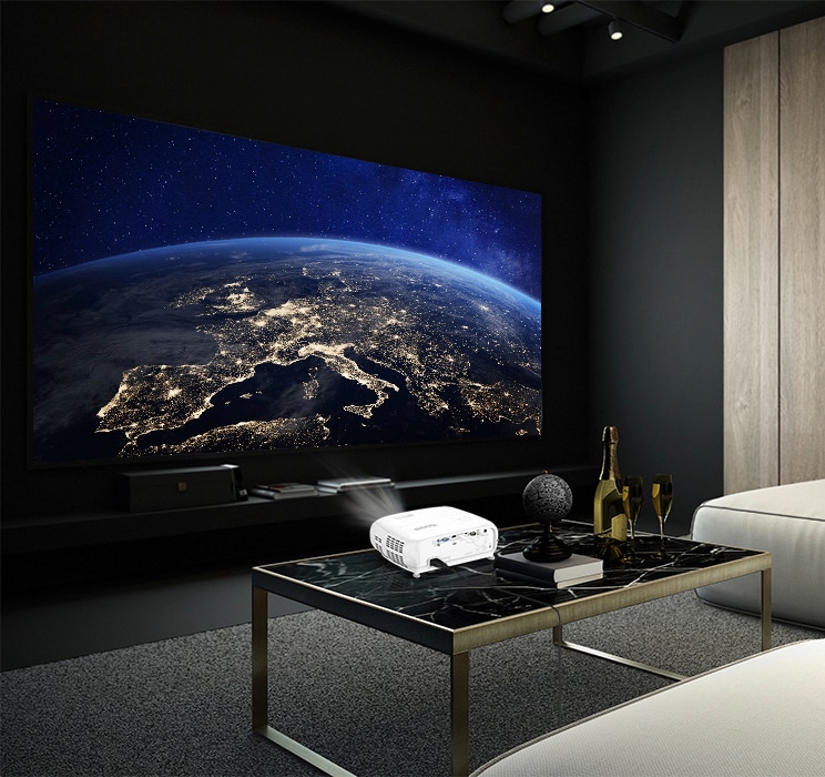 dunkler Raum mit weißen Beamer auf Wohnzimmertisch, der Bild von Weltall projiziert
