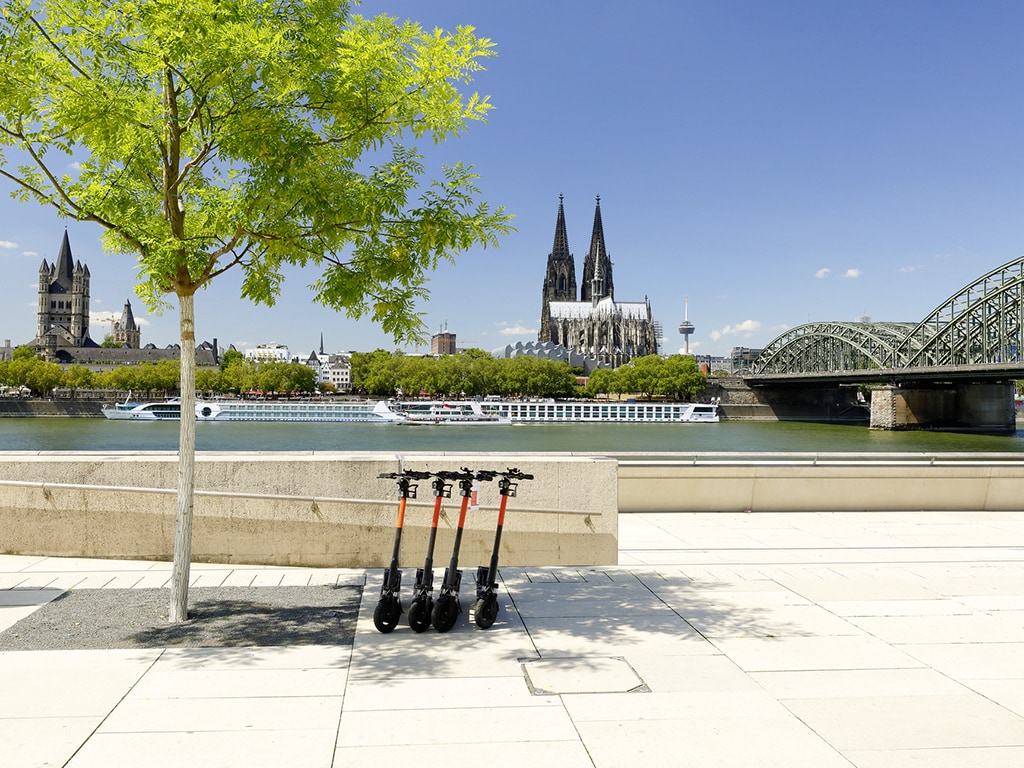 E-Roller stehen am Ufer des Rheins in Köln.