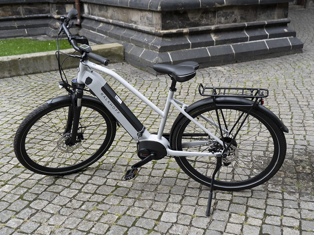 Weißes E-Bike von Kalkhoff auf Pflasterweg abgestellt