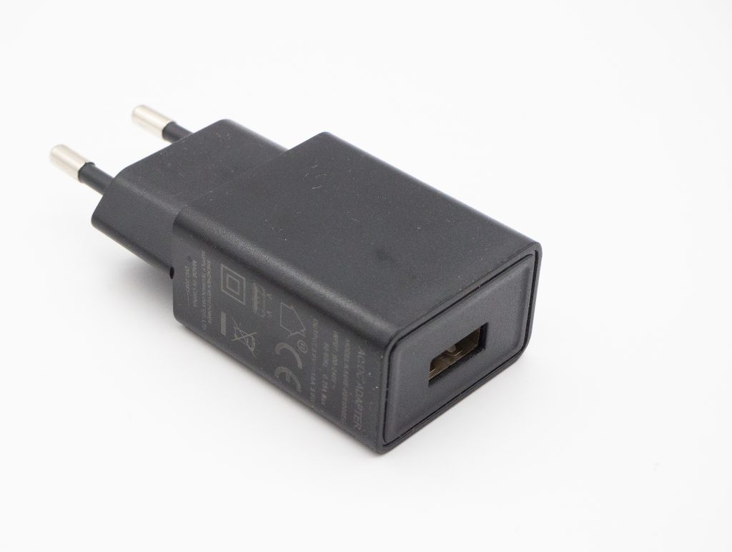 Schwarzer Stecker mit USB-Anschluss auf weißem Hintergrund