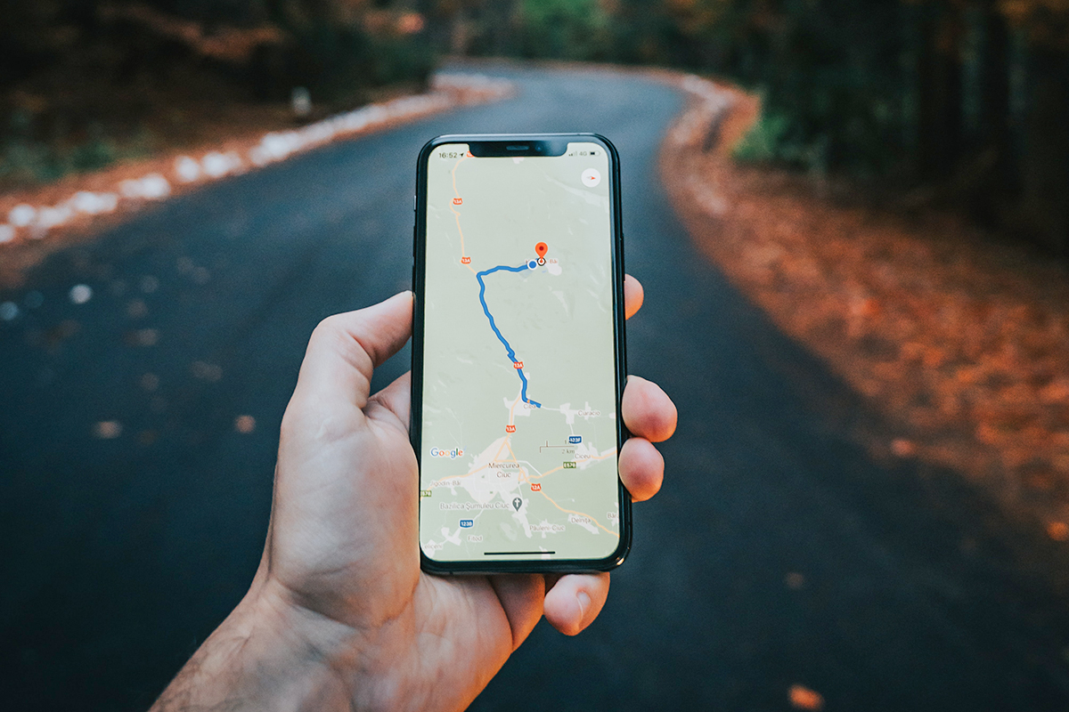 Hand die ein Smartphone hält, mit geöffneter Navigation.