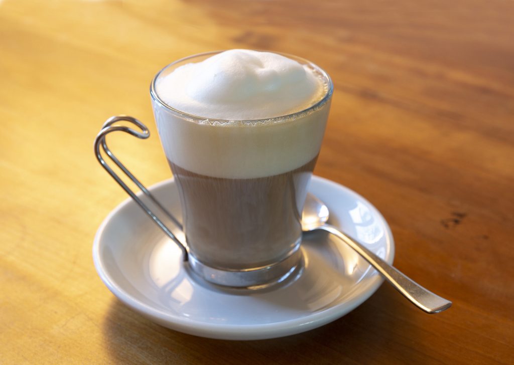 cappuccino in Becher auf Holztisch mit weniger Schaum