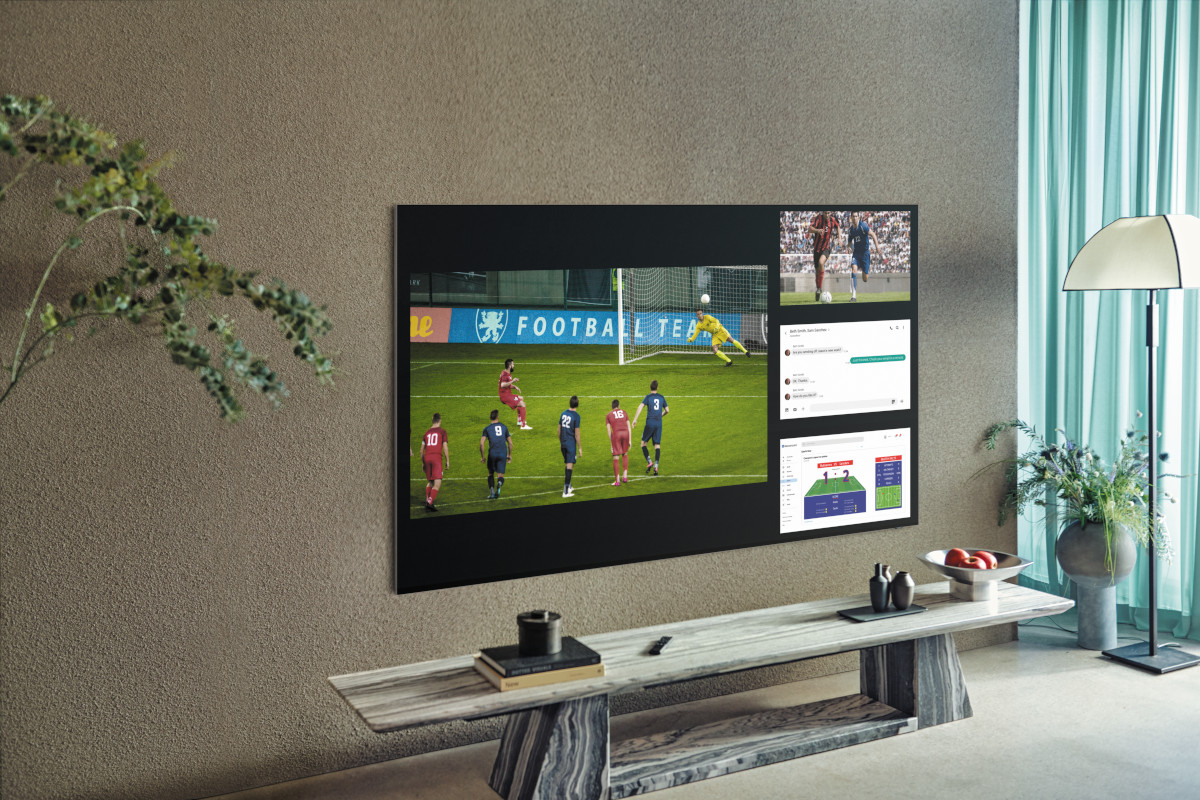 Fernseher zeigt Fußballspiel hängt an Wand über kleinem Sideborárd