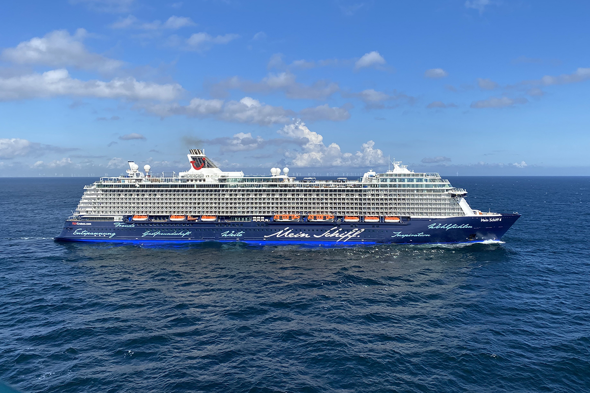 Blick schräg nach unten auf Wasser mit Kreuzfahrtschiff von der Seite