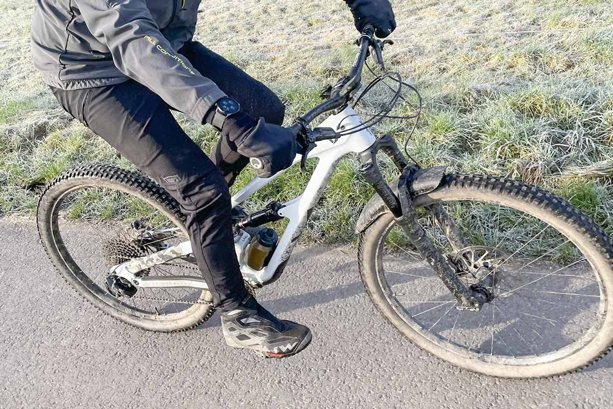 Von schräg oben Blick auf helles Fahrrad mit schwarzgekleideter Person