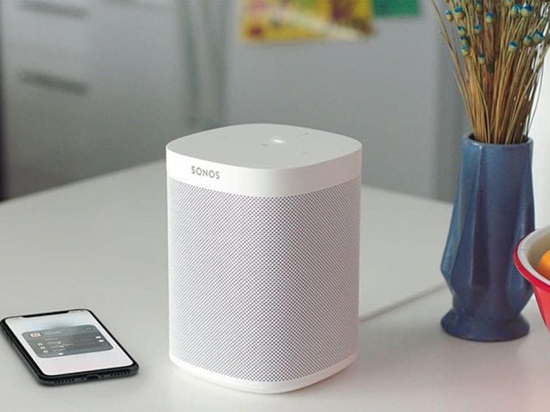 Ein Bluetooth-Lautsprecher von Sonos steht neben einem Smartphone auf einem Küchentresen.