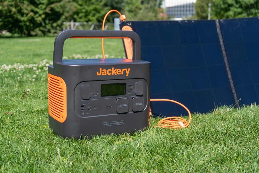 Die Jackery Explorer 2000 Pro wird in einem Park an einem Solarpaneel aufgeladen.
