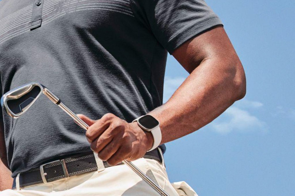Die Fitbit Sense 2 am Arm eines Golfspielers