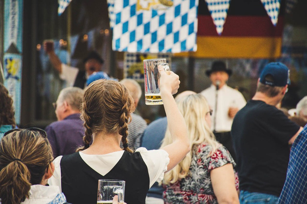 Eine Frau, die in einer Menge steht und ein Bierglas hält