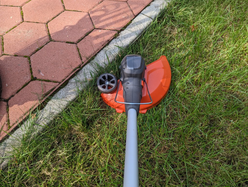 Der Trimmerkopf in waagerechter Position an einer Terrassenkante