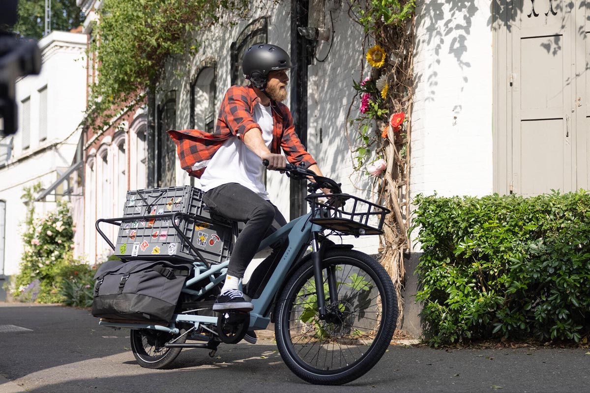 Ein Mann fährt draußen auf dem Decathlon Cargobike R500E Longtail