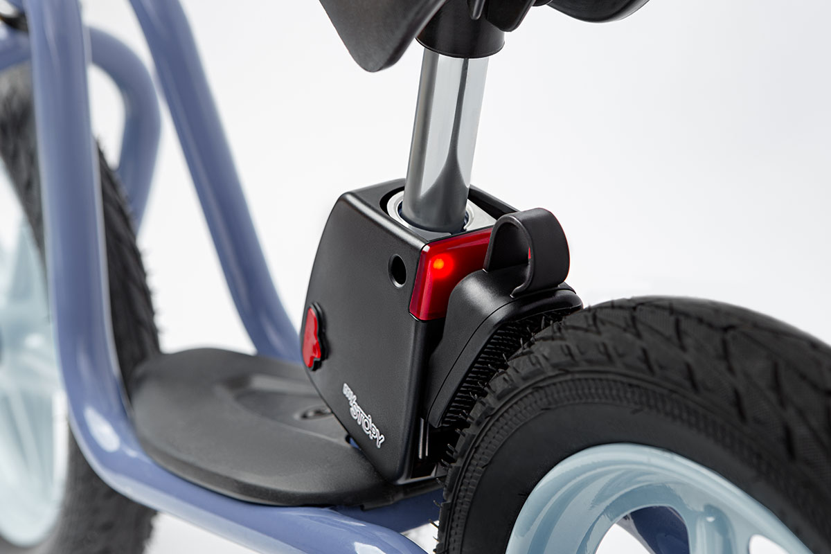 Bremsvorrichtung für Laufräder. Produktansicht im Detail mit Bremse eingebaut in Laufrad – Ansicht schräg von hinten vor weißem Hintergrund.