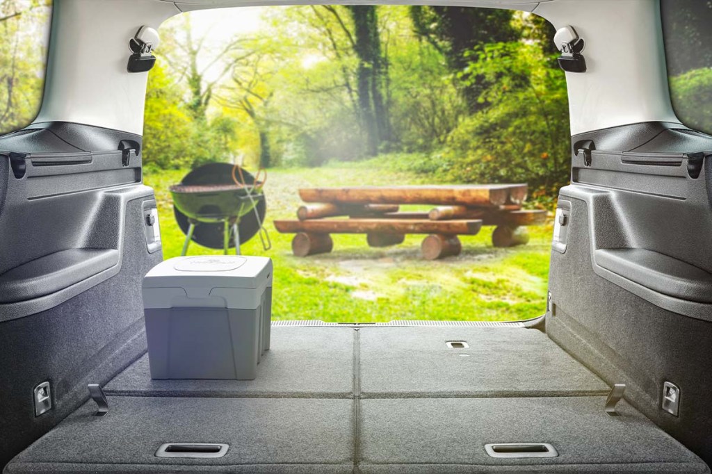 Blick aus einem Camper nach draußen - Campingtoilette steht im Kofferraum