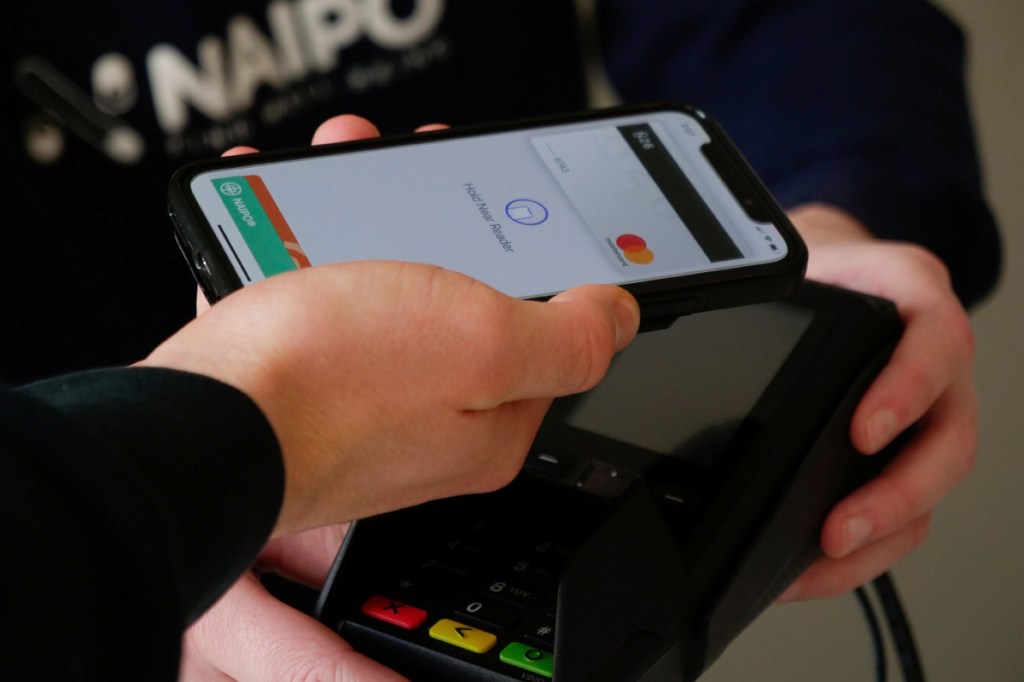 Eine Person bezahlt mit Apple Pay.