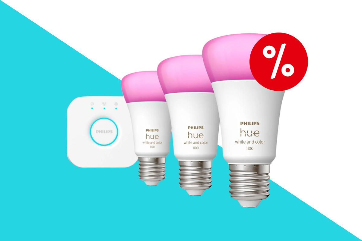 Drei Philips Hue Lampen mit weißem Sockel und pink leuchtenden LEDs in Reihe versetzt aufgestellt mit weißem quadratischem Gerät am linken Ende der Reihe auf türkis weißem Hintergrund mit rotem Prozentzeichen rechts oben
