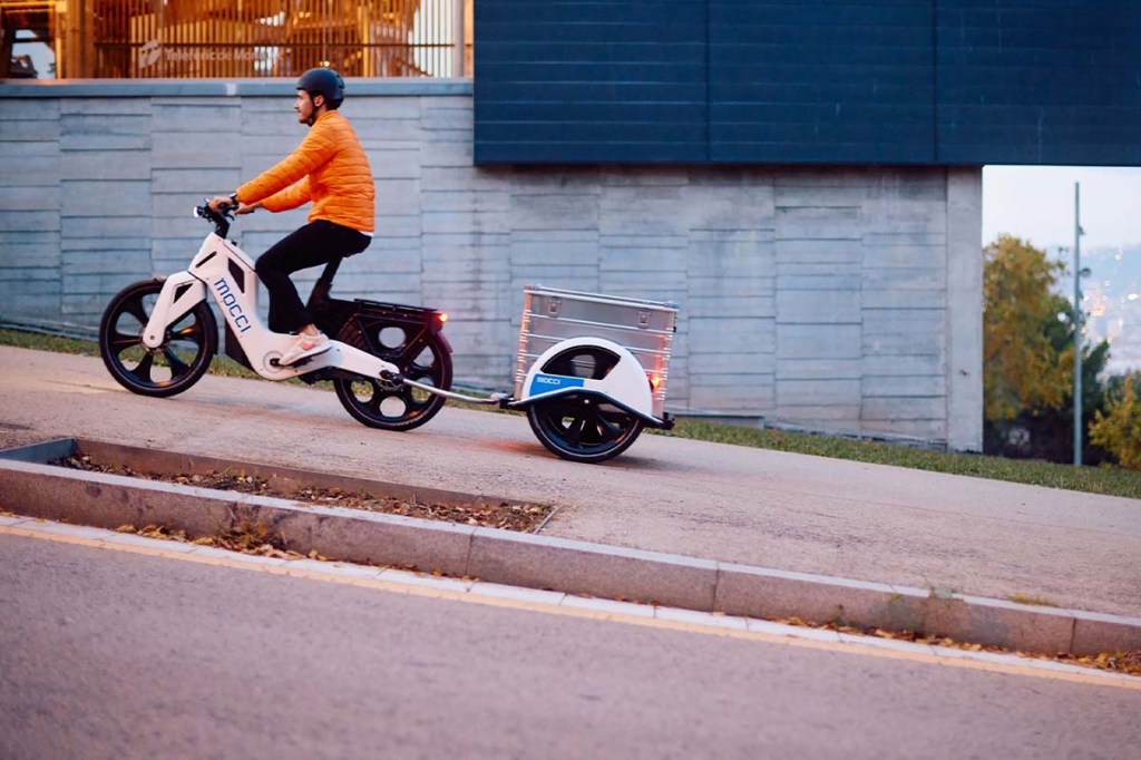 Mann fährt mit E-Cargo-Bike einen Anstieg hoch.
