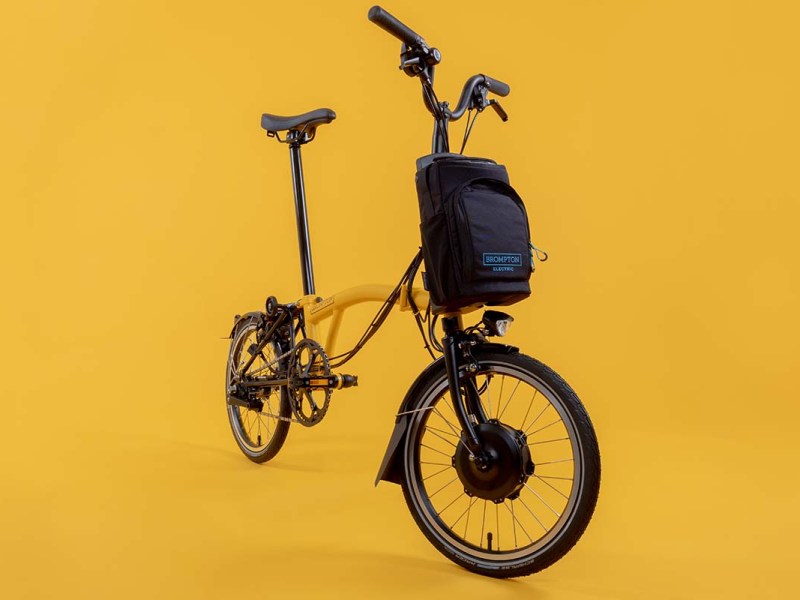 Productshot E-Faltrad Electric C Line von Brompton auf gelben Hintergrund