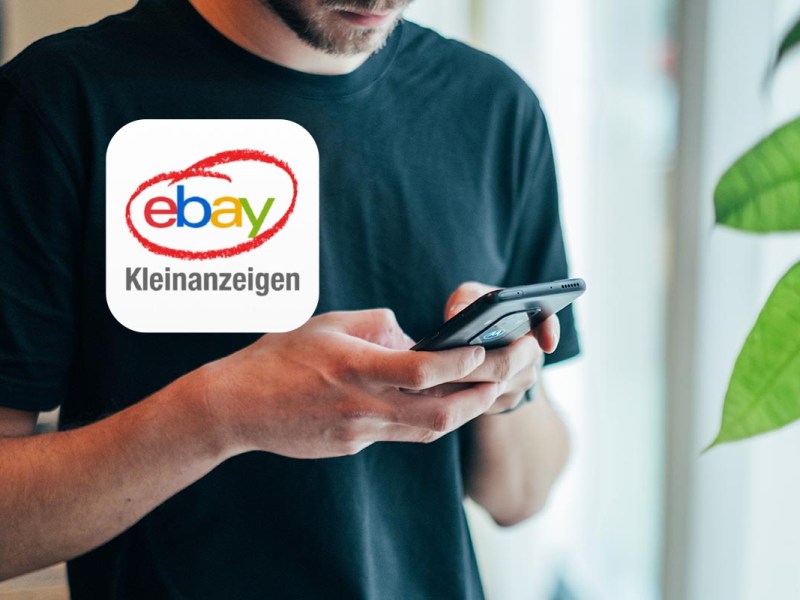 Ein mann hält ein Smartphone in der Hand, davor das Kleinanzeigen-Logo