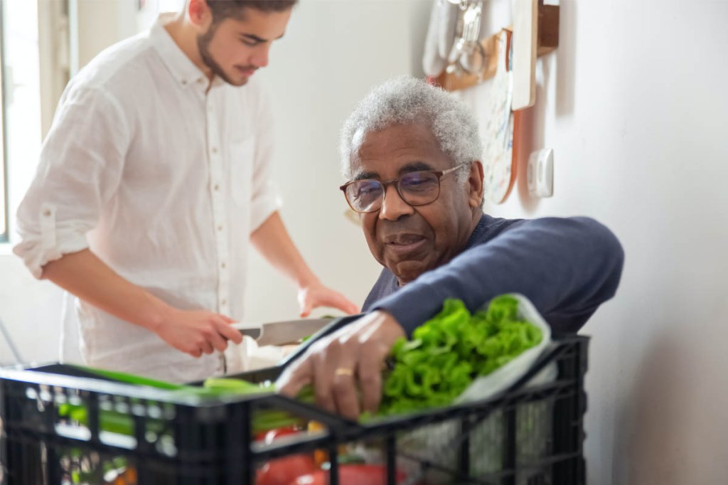 Ein junger und ein alter Mann kochen gemeinsam.