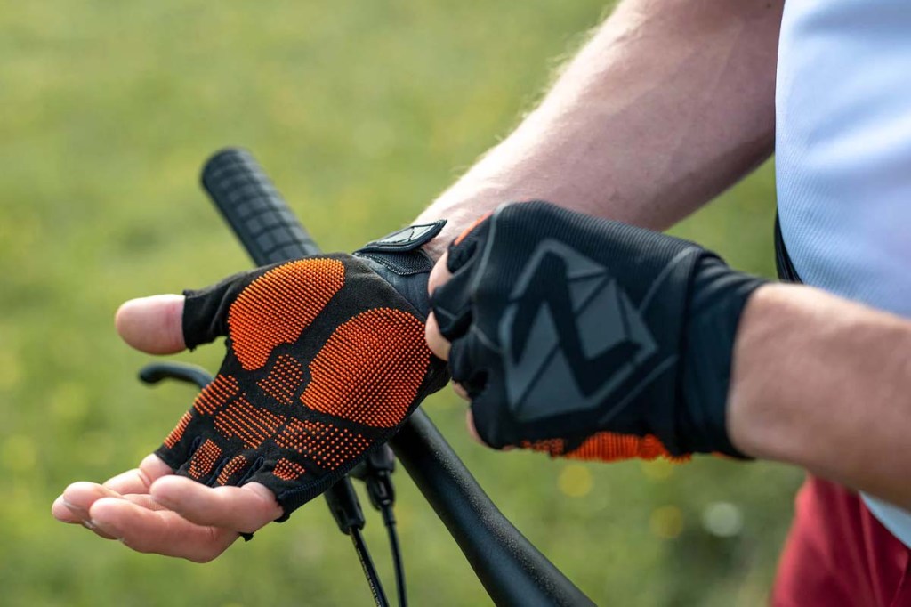 Fahrradhandschuhe Cecko von Ziener, Person rückt Handschuh an der Hand sitzend zurecht