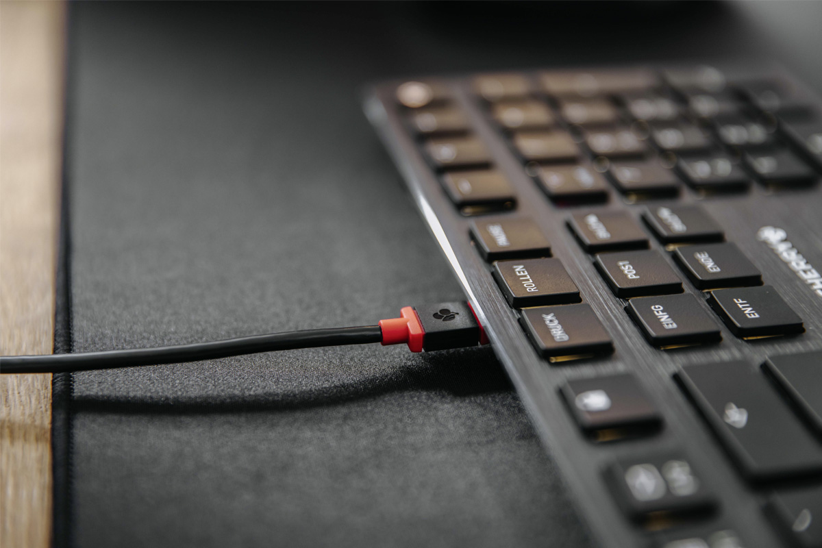 Ein USB-Kabel ist an die Tastatur angeschlossen.