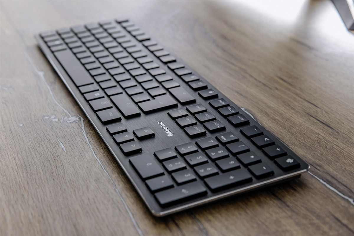 Die neue Cherry-Tastatur liegt auf einem Holztisch.