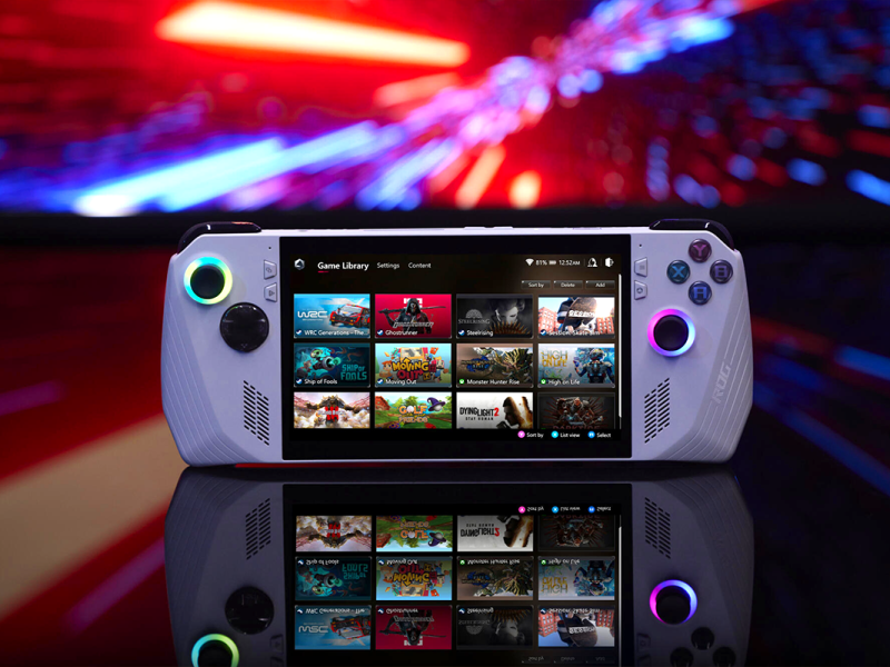 Das weiße Gaming-Handheld auf einer spiegelnden Oberfläche vor einem verschwommenen, bunten Hintergrund