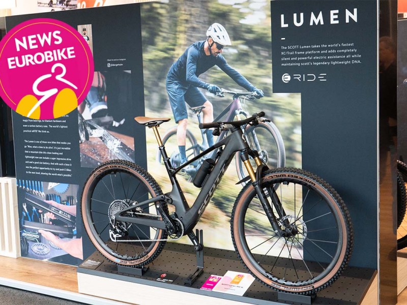 E-Mountainbike steht auf einem Aufsteller, dahinter eine Infowand