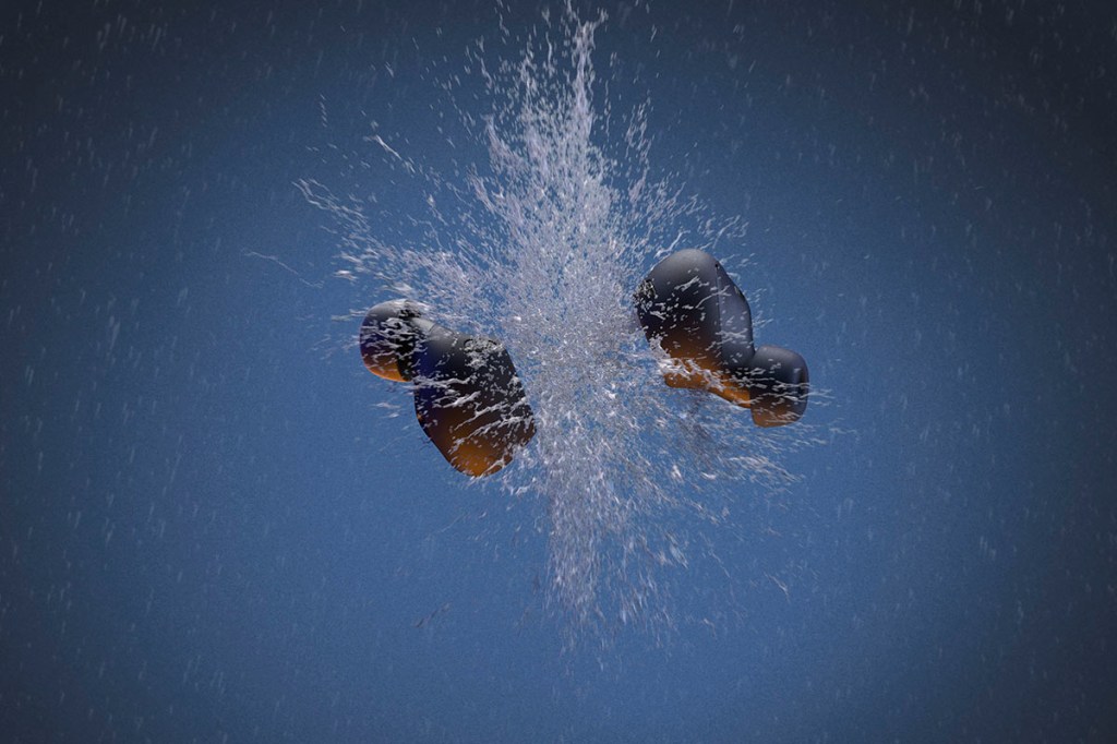 Zwei In-Ear-Kopfhörer von Jabra fliegen durch einen Wasserstrahl.