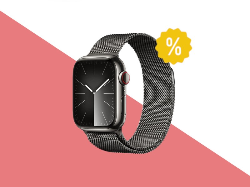 Apple Watch 9 mit silbernem Armband und Gehäuse und dunklem Ziffernblatt schräg von vorne auf rot weißem Hintergrund mit gelben Prozentzeichen oben rechts