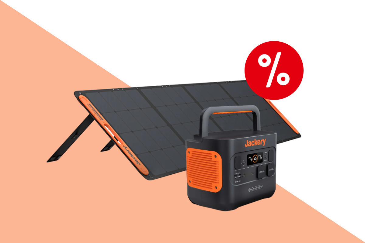 Jackery schwarz orangene Powerstation schräg von vorne vor einem aufgestellten schwarz orangenem Solarpanel auf orange weißem Hintergrund mit rotem Prozentzeichen oben rechts