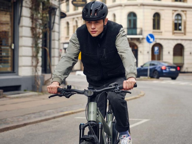 Mann fährt mit einem E-bike durch eine Stadt