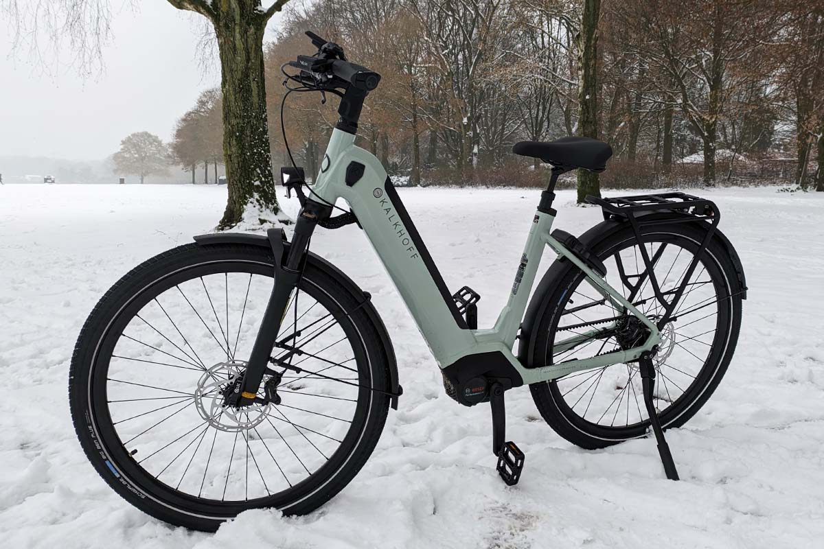 weißes E-Bike in einem verschneiten Park stehend