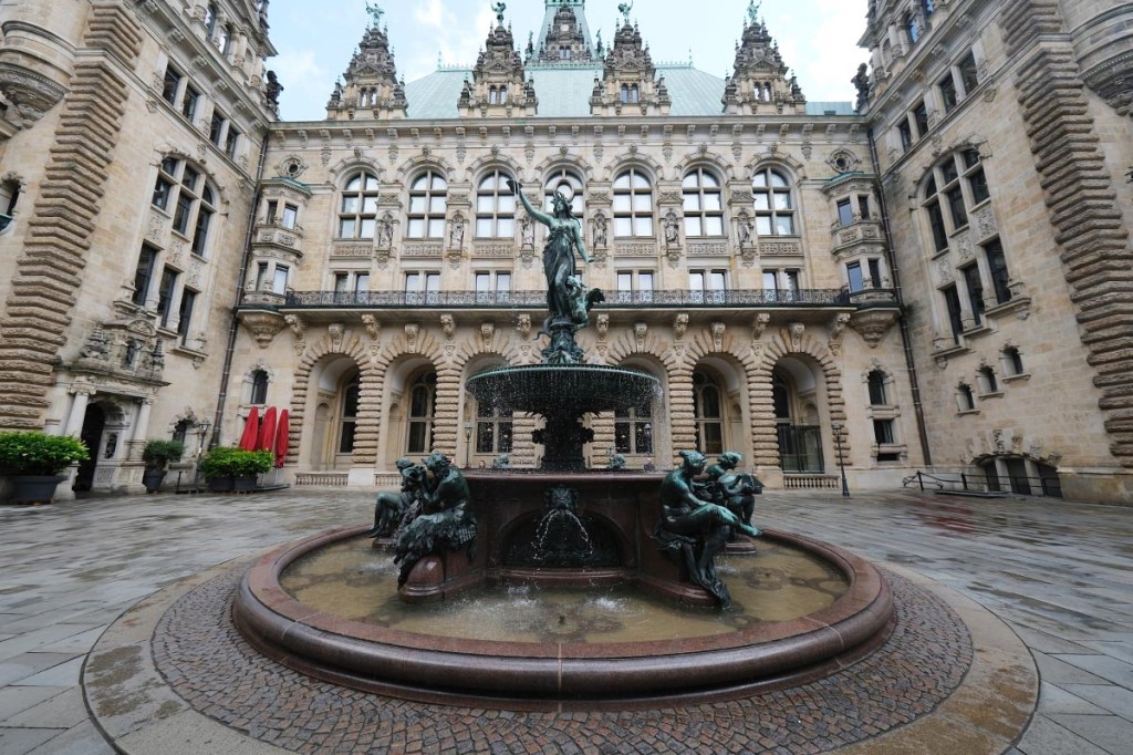 Springbrunnen umringt von einem Gebäude.