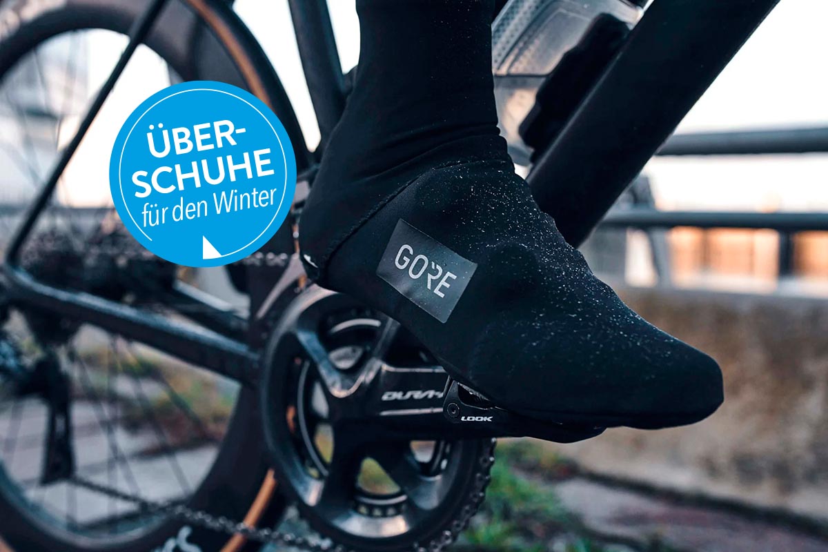 Person auf einem Fahrrad mit Überschuhen.