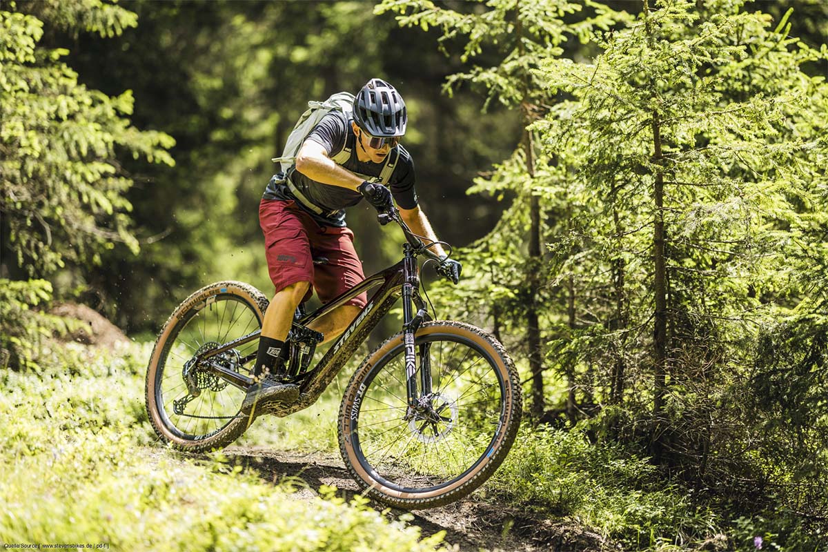 Mann fährt mit einem E-Mountainbike durch den Wald