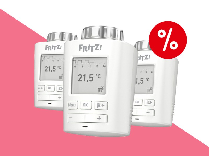 Drei weiße Fritz Dect 301 Thermostate in Reihe, einer vorgestellt schräg von vorne auf pink weißem Hintergrund mit rotem Prozentbutton oben rechts