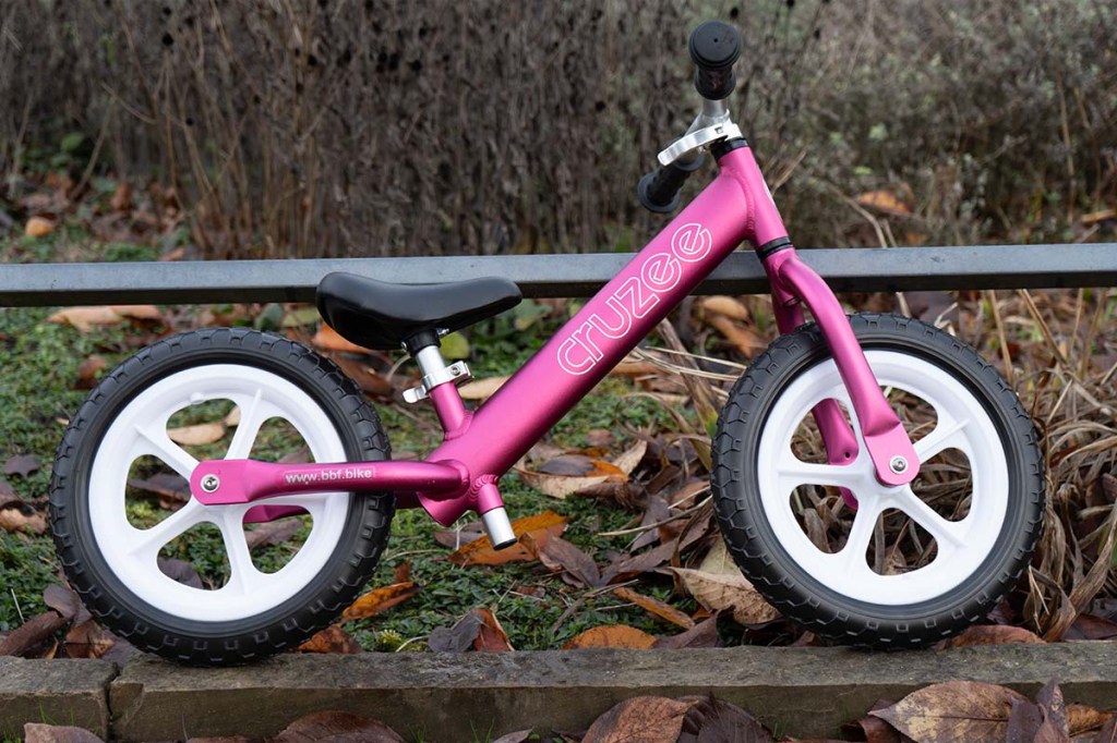 pink-farbenes Laufrad in einem Park stehend
