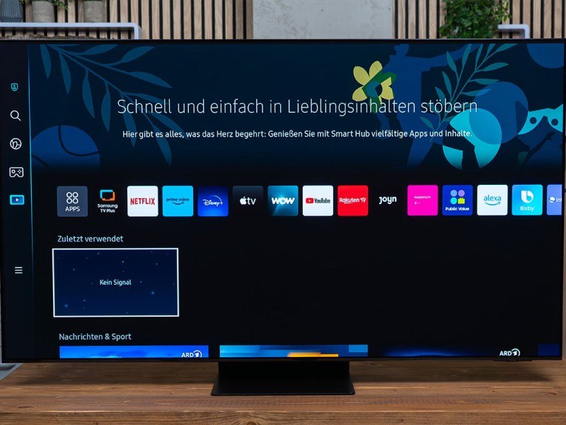 Smart TV von Samsung mit eingeschlatetem Bildschirm stehend und frontal abgelichtet auf einem Holztisch.