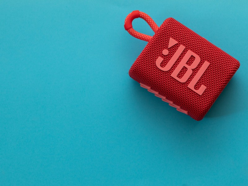 Die rote JBL Go 3 vor blauem HIntergrund.