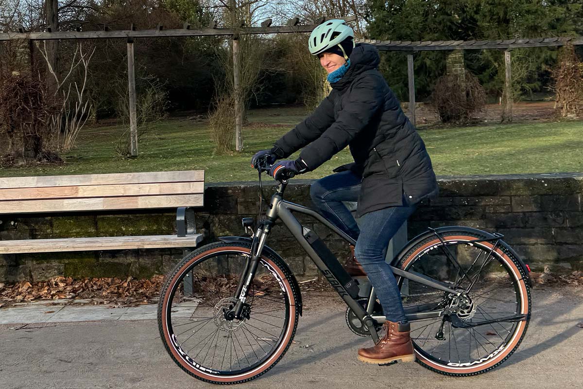 Frau fährt mit einem E-Bike durch einen Park