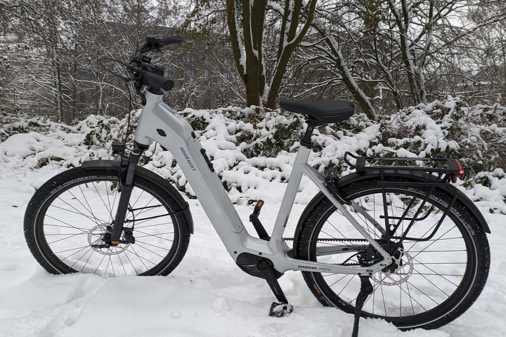 Totale weißes E-Bike, welches im Schnee steht