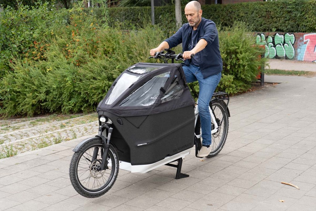 Mann sitzt auf einem Cargo-E-bike