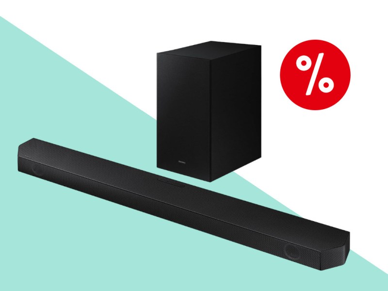 Schwarze Samsung-Soundbar schräg von vorne mit hochkant gestelltem schwarzem eckigem Subwoofer darüber auf türkis weißem Hintergrund mit rotem Prozentbutton oben rechts