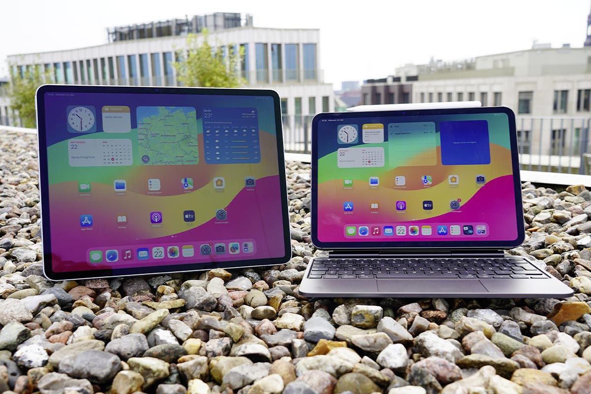 Zwei iPads stehen auf Kies im Freien.