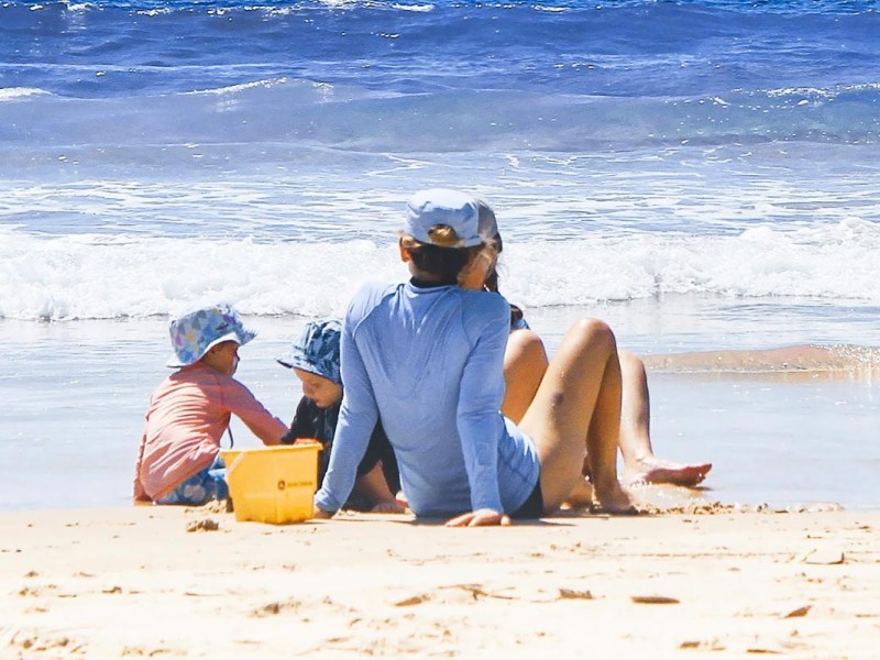 Familie mit Kindern an einem Strand.