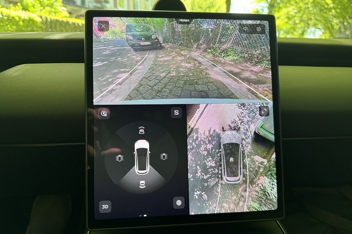 Blick auf das Infotainment-Display des E-Autos Nio ET5 Touring mit Anzeigen, die die Kameras des Autos beim Ausparken liefern. 