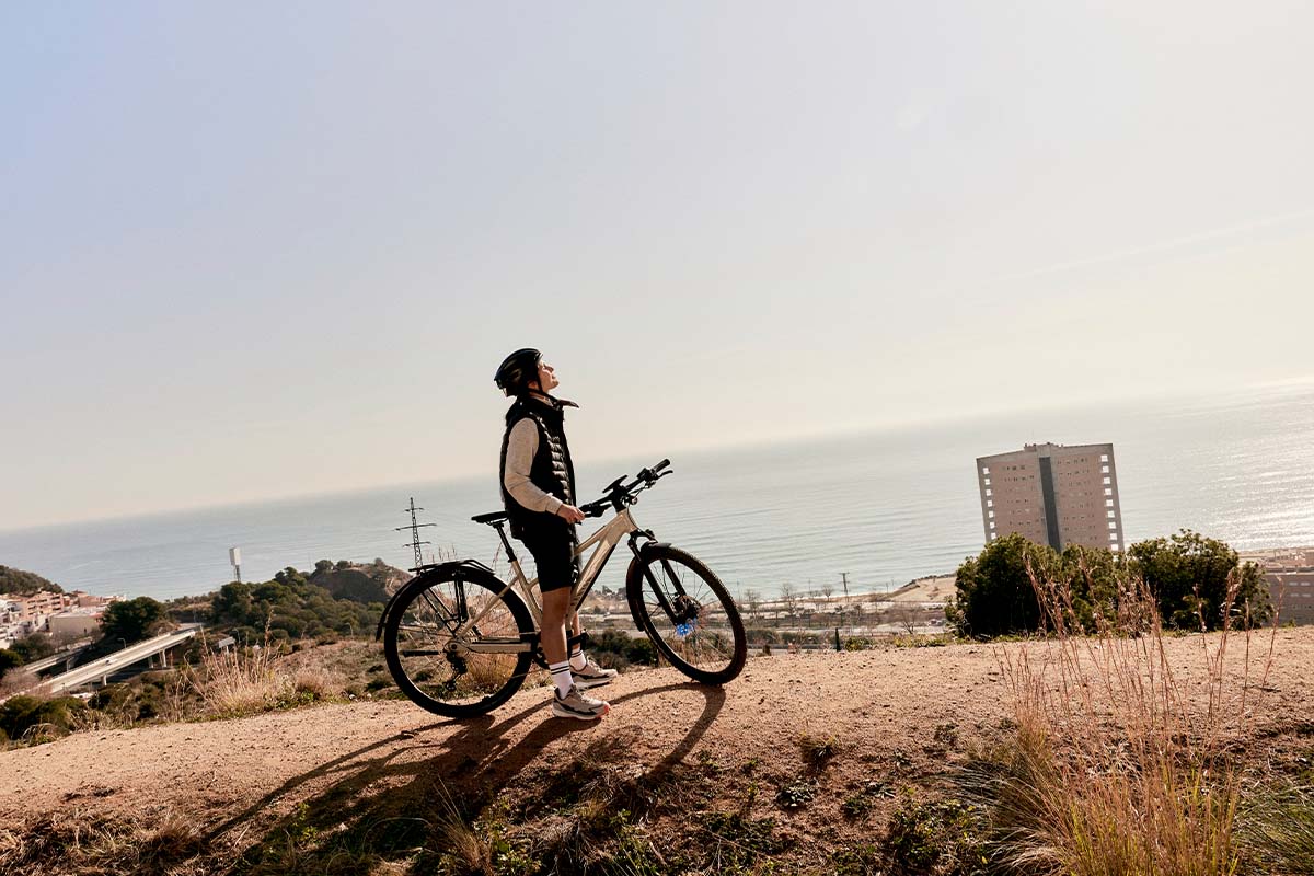 Person auf einem E-Bike, Natur und Meer im Hintergrund