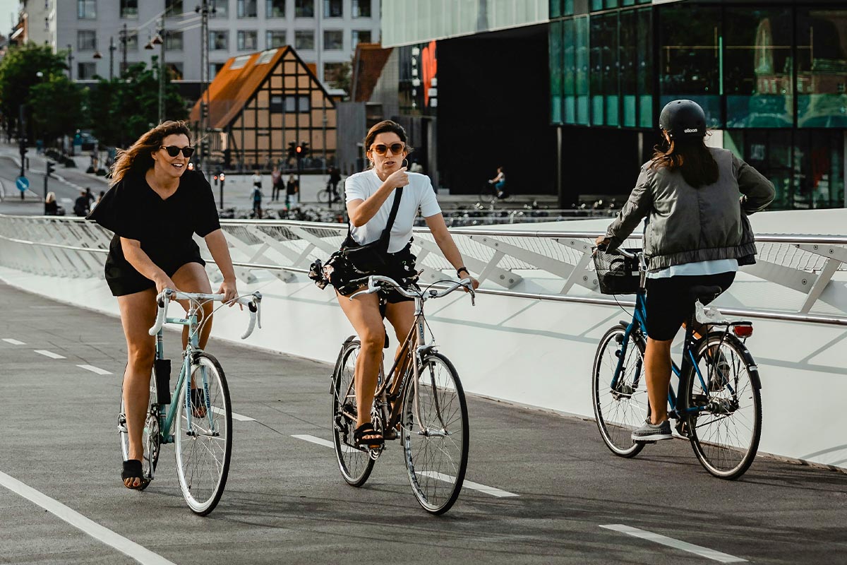 Drei Personen auf einem Fahrrad auf der Straße.